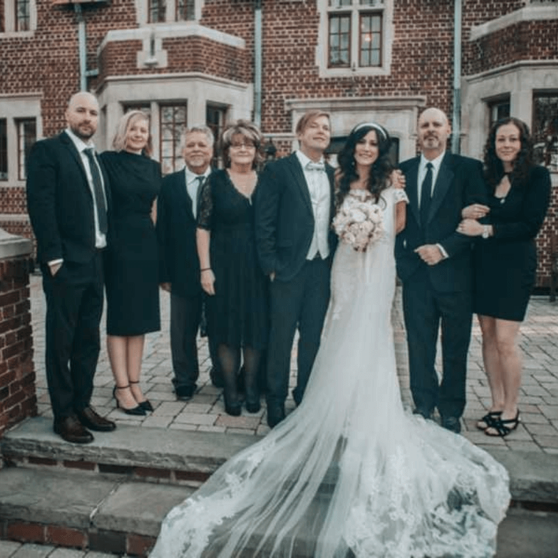 Best of 2021 - Group Photo of a Wedding Standing in Front of a Brick Building